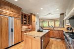 The full kitchen features granite countertops and an island that serves as a breakfast bar for casual meals